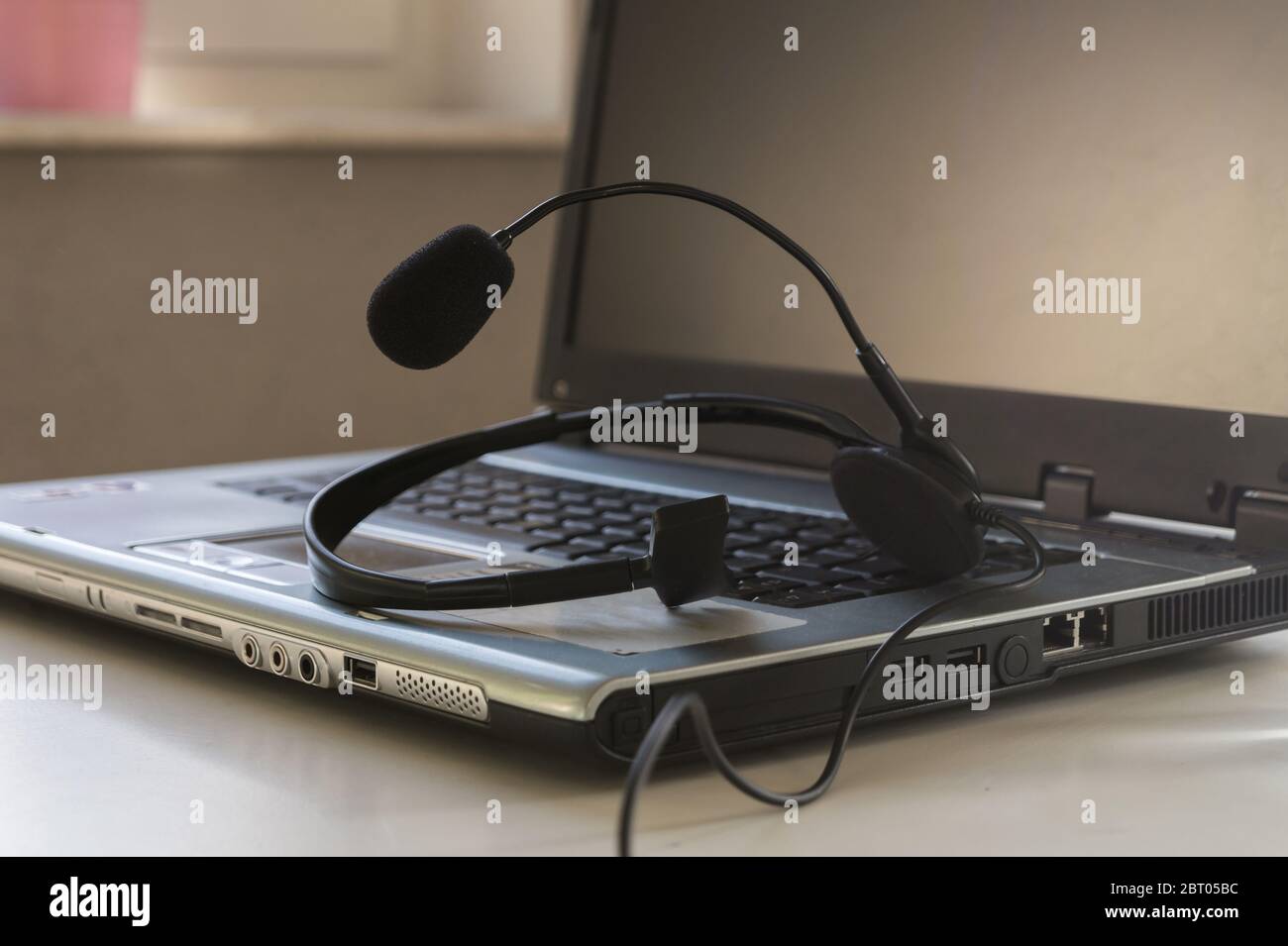 PC portatile e cuffie su un tavolo. Concetto di lavoro in ufficio domestico e conferenza online. Foto Stock