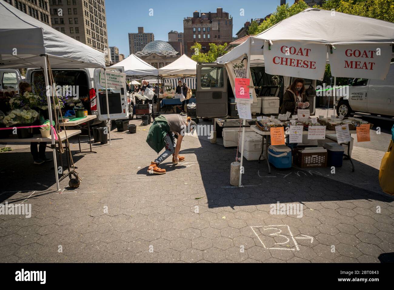 Un lavoratore presso l'Union Square Greenmarket di New York segna con gesso gli spazi di allontanamento sociale mercoledì 13 maggio 2020. (© Richard B. Levine) Foto Stock