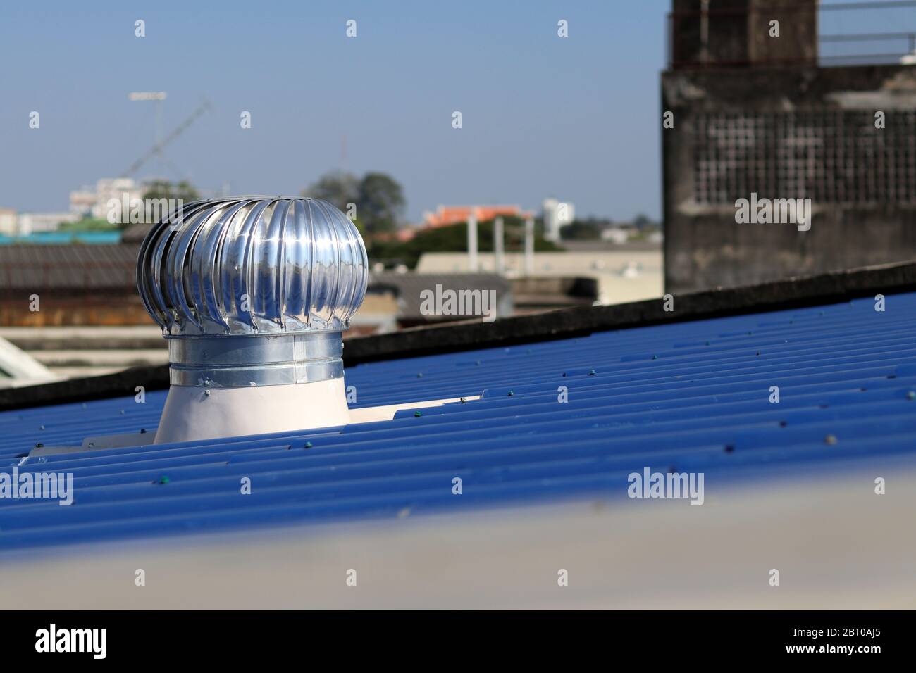 Ventilatore a turbina installato sul tetto blu. Il ventilatore a turbina aiuta l'aria a fluire in qualsiasi momento. Foto Stock