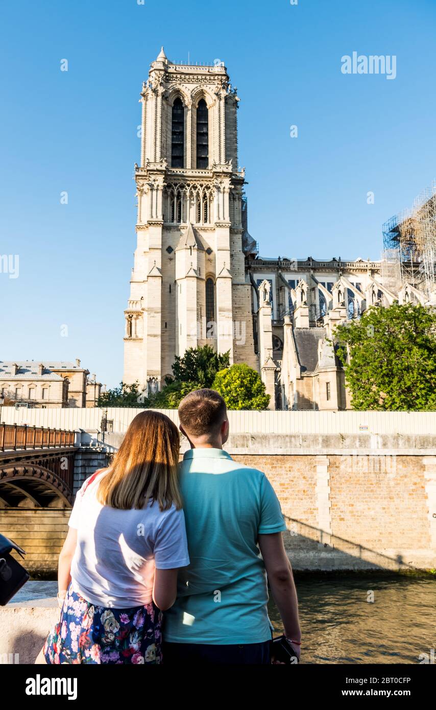 Una giovane coppia che guarda alla torre della Notre-Dame de Paris dopo il grande fuoco, una cattedrale cattolica medievale sul Île de la Cité nel 4 arro Foto Stock