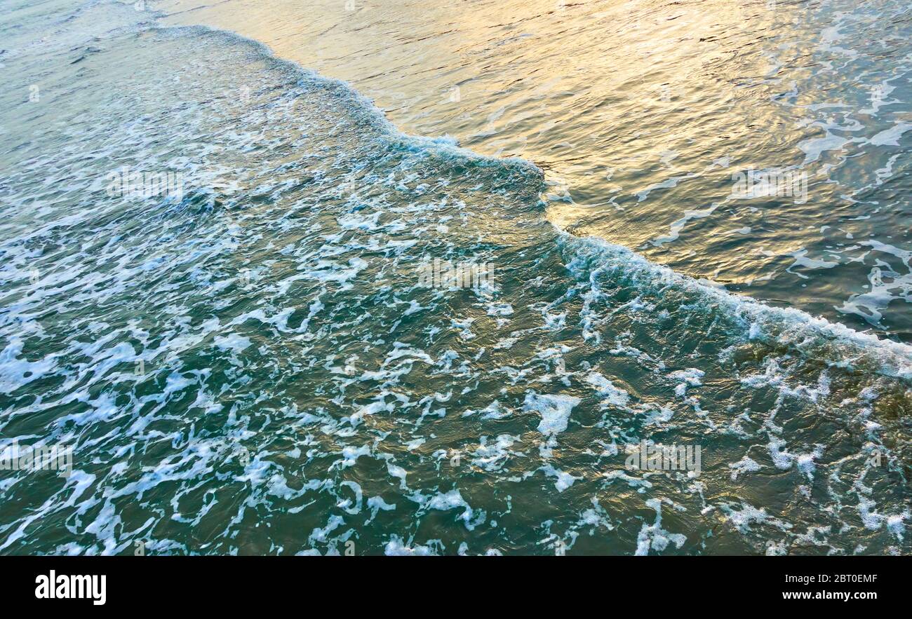 Surf in mare - la superficie dell'acqua nella luce della sera può essere usata come sfondo Foto Stock