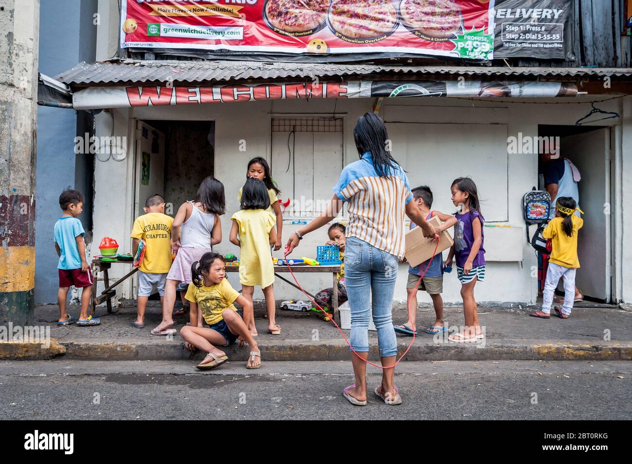 I bambini filippini giocano per strada nella vecchia città murata di Intramuros, Manila, Filippine. Foto Stock