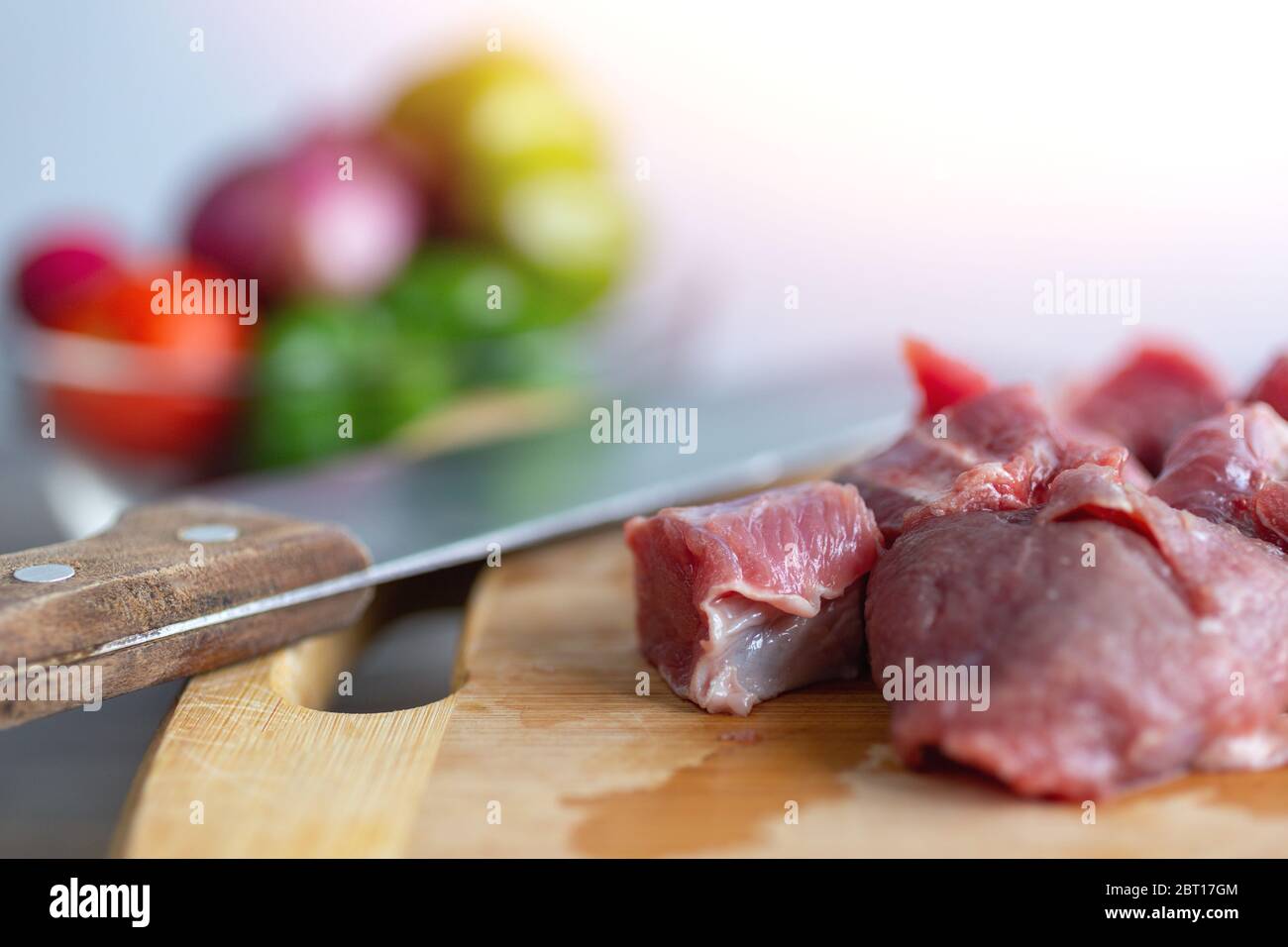 Primo piano di carne tagliata a cubetti di manzo stufato pezzi su tavola di legno. Cucina cena sul tavolo concetto cucina Foto Stock