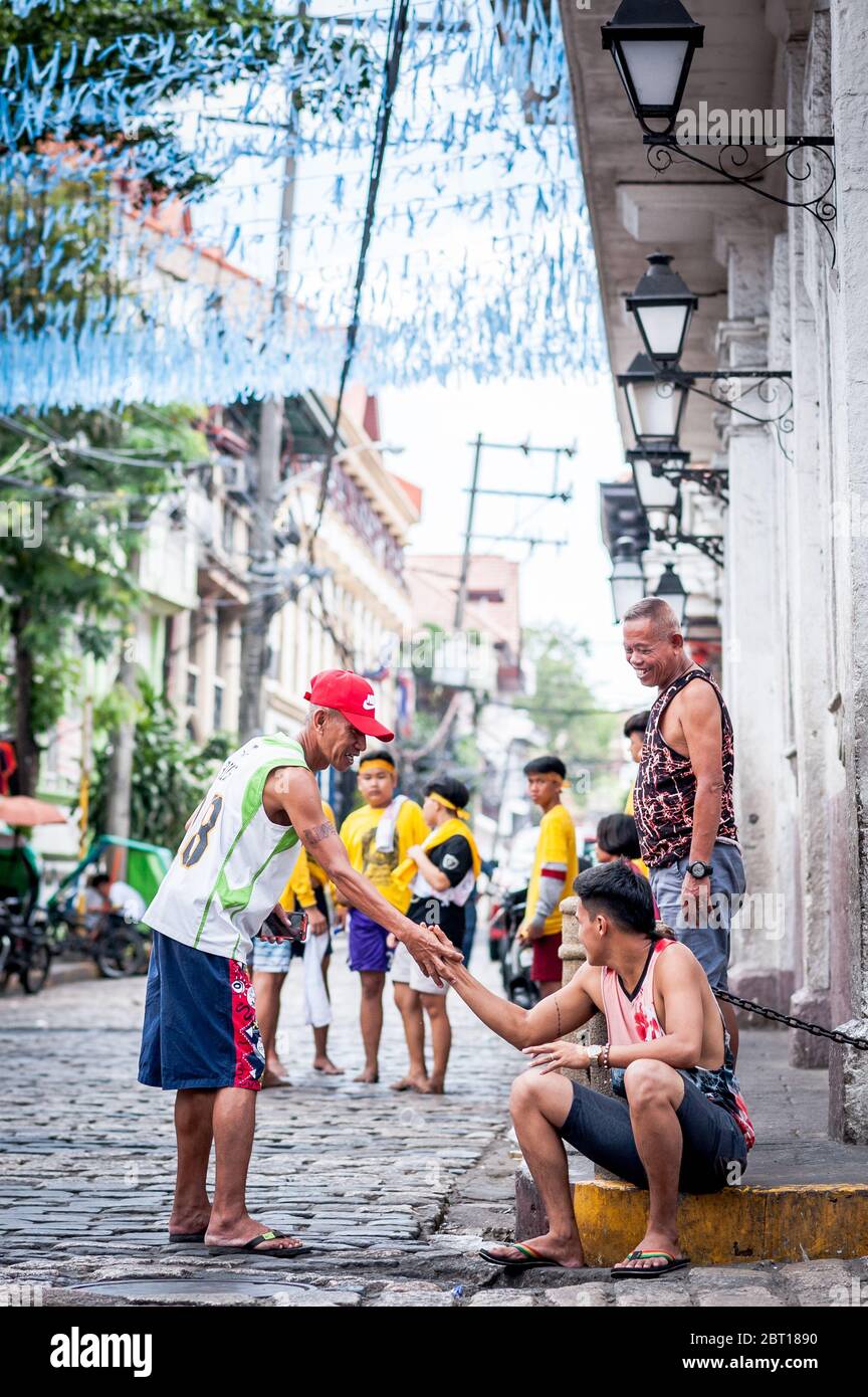 Un felice uomo filippino scherza con gli amici nella vecchia città murata di Intramurous, Manila, le Filippine. Foto Stock