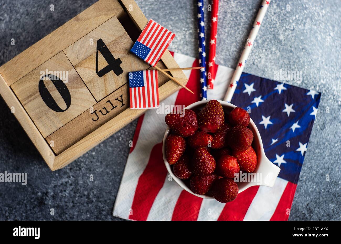 4 luglio celebrazione Card concetto con fragole fresche e roba festivo su sfondo grigio con spazio copia Foto Stock