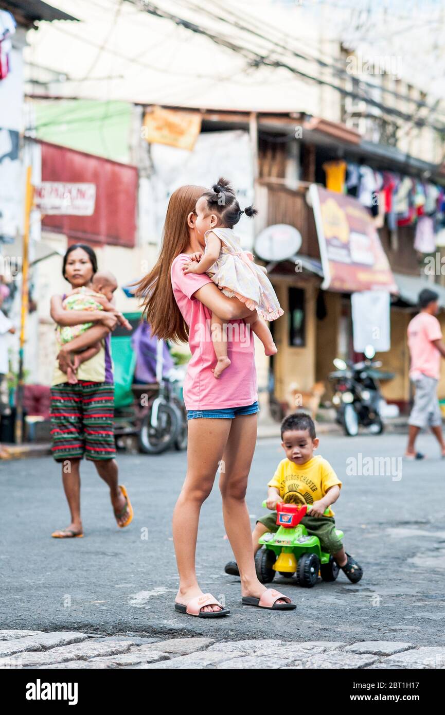 Scatti candidi famiglie e bambini che si sono recati al loro lavoro quotidiano nella vecchia città murata Intramurous Manila, le Filippine. Foto Stock