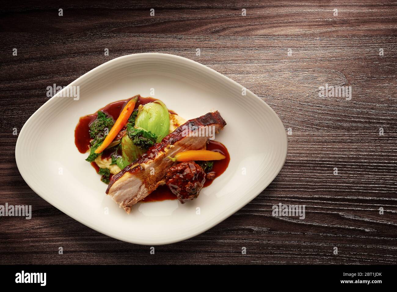 Direttamente sopra un'elegante piatto di cucina Nouvelle con maiale arrosto affettato su verdure Foto Stock