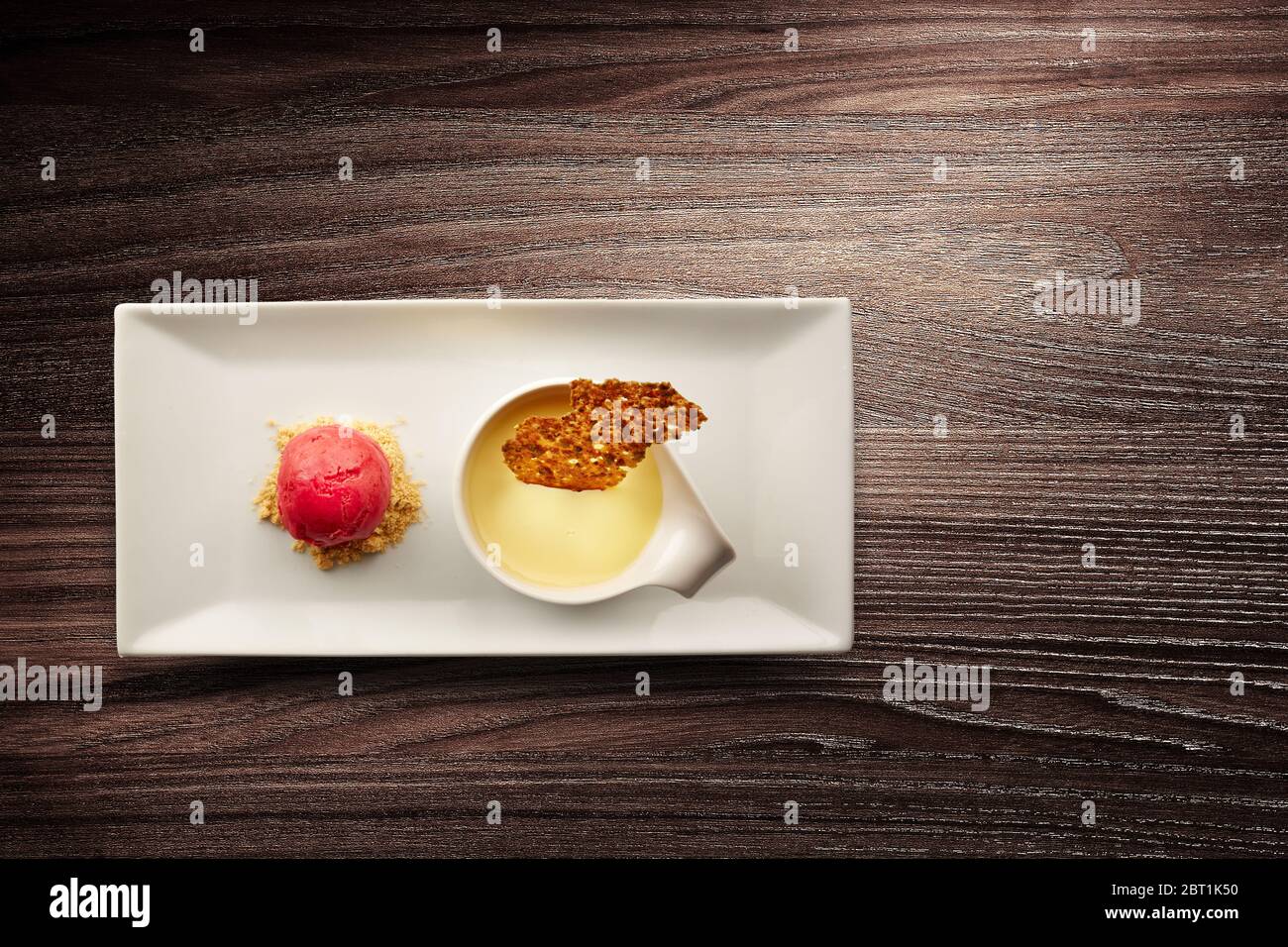 Direttamente sopra un'elegante piastra di cucina nouvelle di creme brulee su sfondo di legno Foto Stock