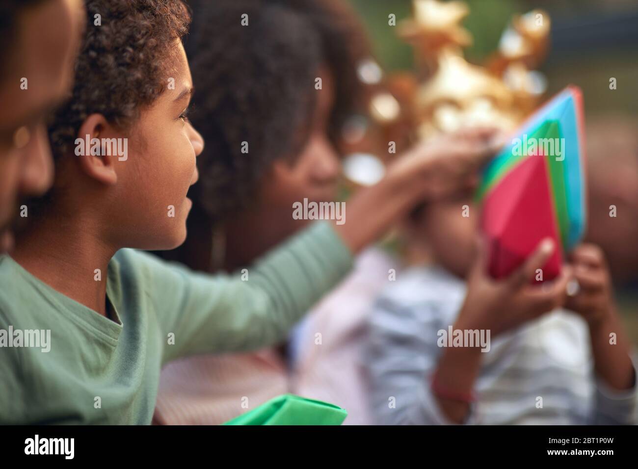 Afro american cute bambina e ragazzo giocando con barche di carta. Foto Stock