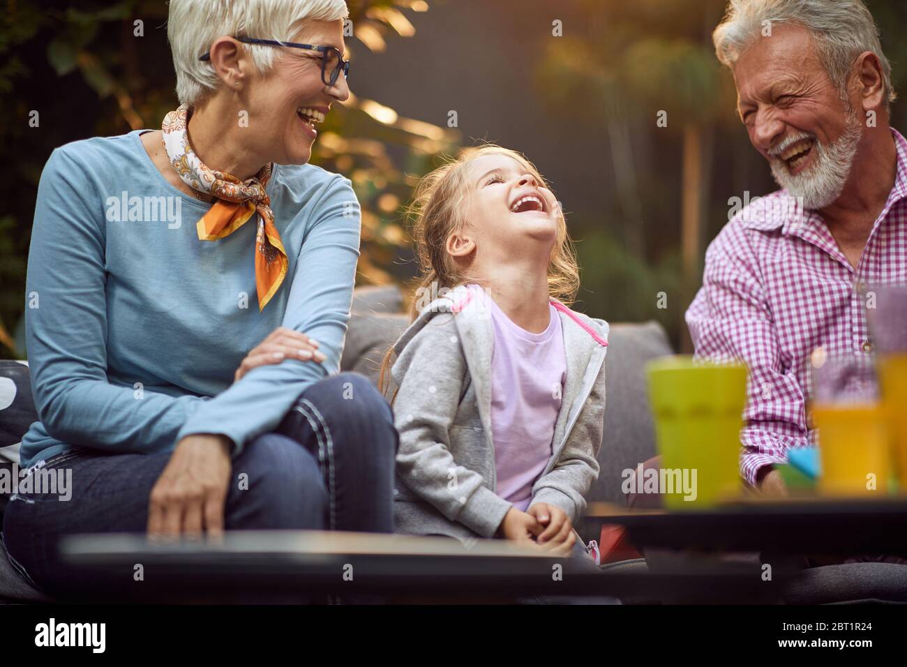 Felice nipote ridere con il suo nonni.felice infanzia, famiglia e relazioni concetto. Foto Stock