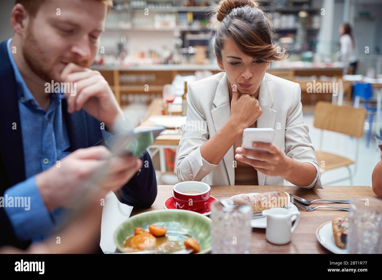 uomini d'affari a pranzo, non parlando, preoccupati, dopo covid, distratti l'uno dall'altro dai telefoni cellulari. non presente, problemi sociali, recessioni, probl Foto Stock
