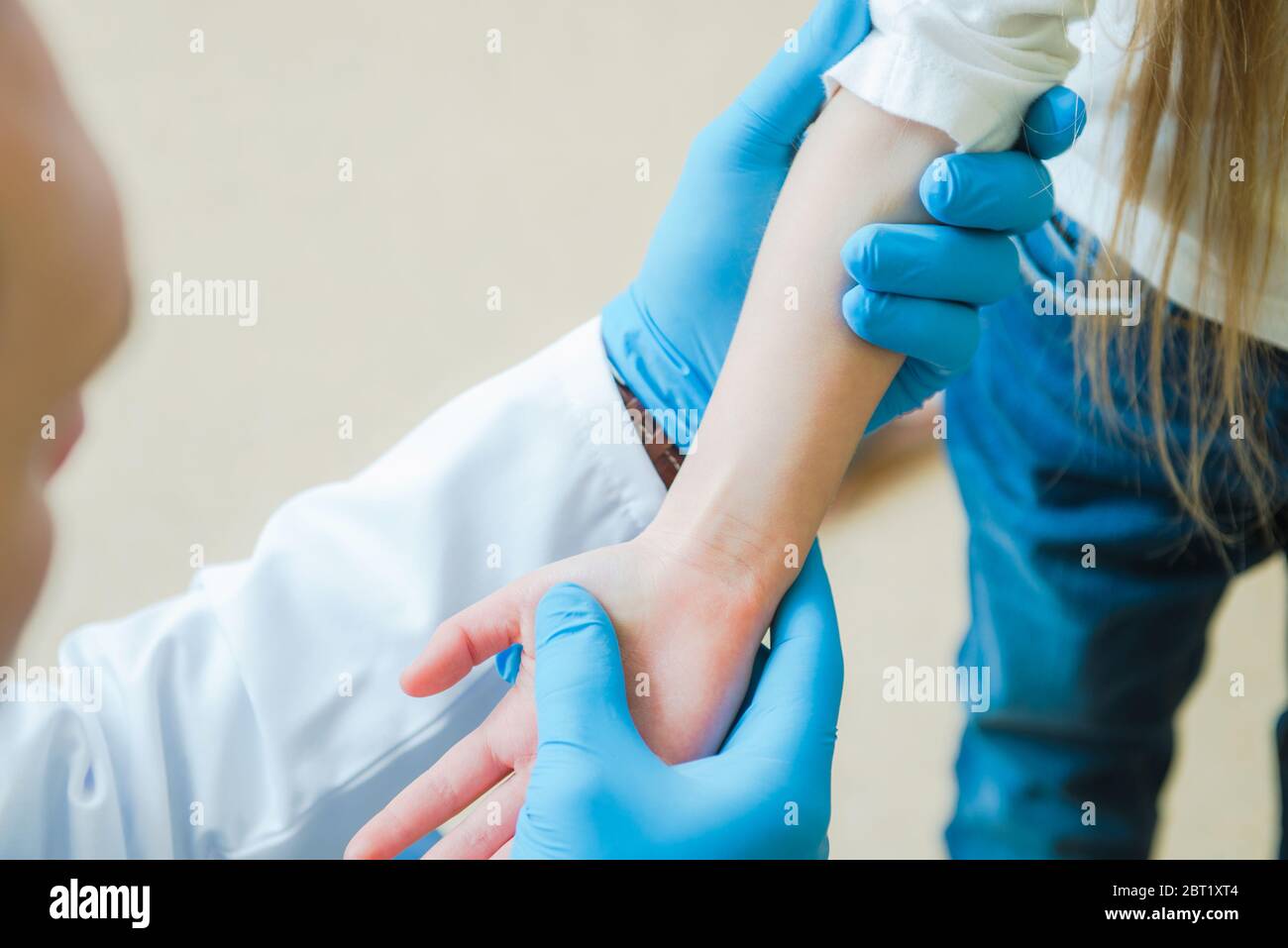 Caucasico maschio medico esaminante mano e braccio di giovane paziente femminile presso l'ufficio medico. Foto Stock