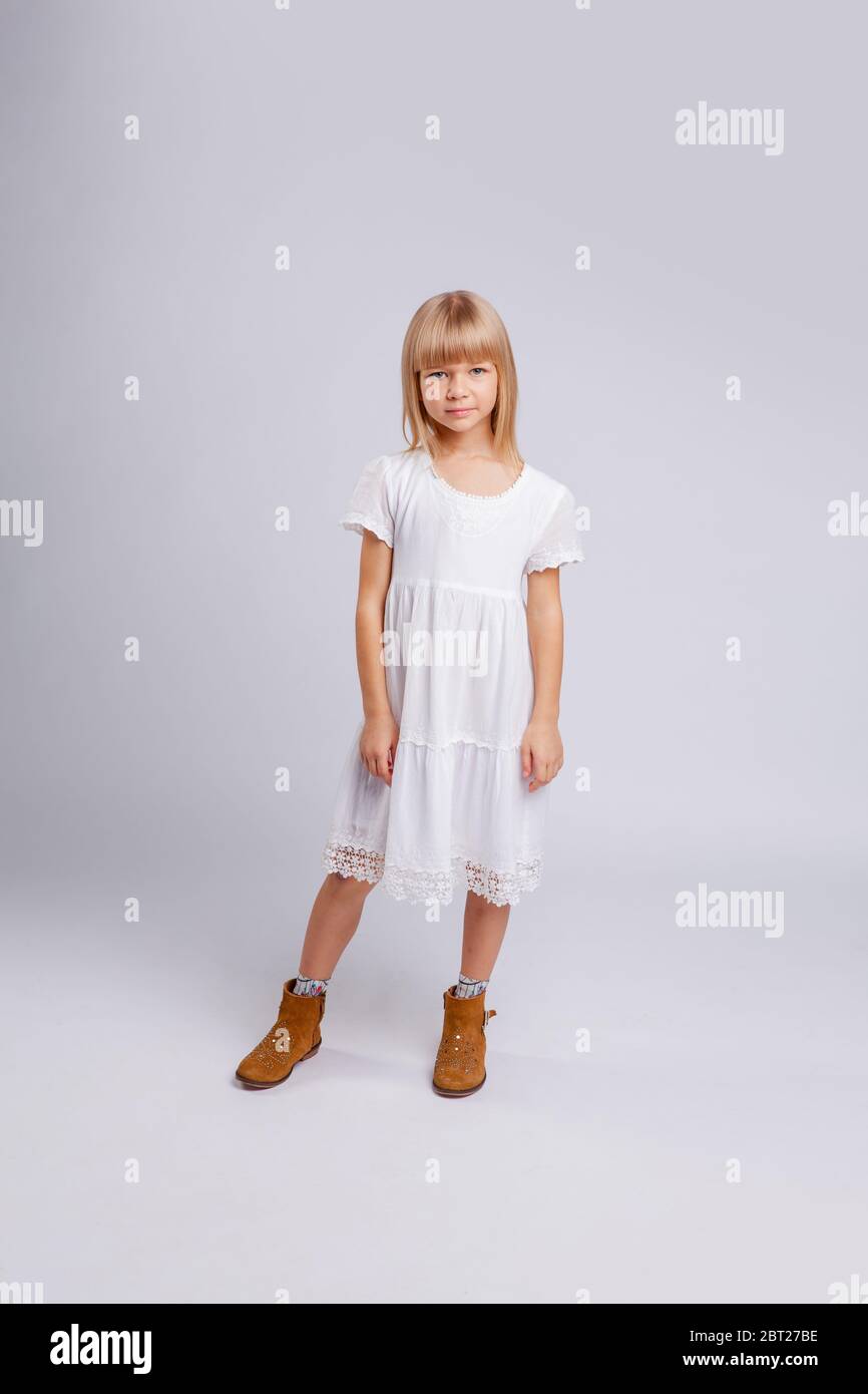 bambina in un vestito bianco si leva in piena crescita Foto Stock