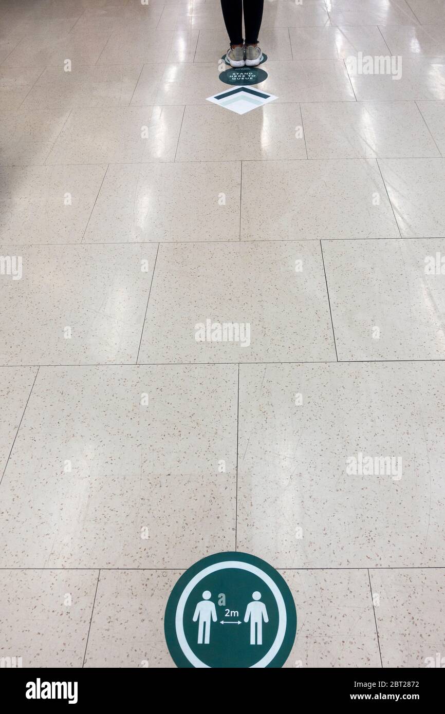 Marcatori di distanza sociale sul pavimento in un M&S Foodhall Nel Regno Unito Foto Stock