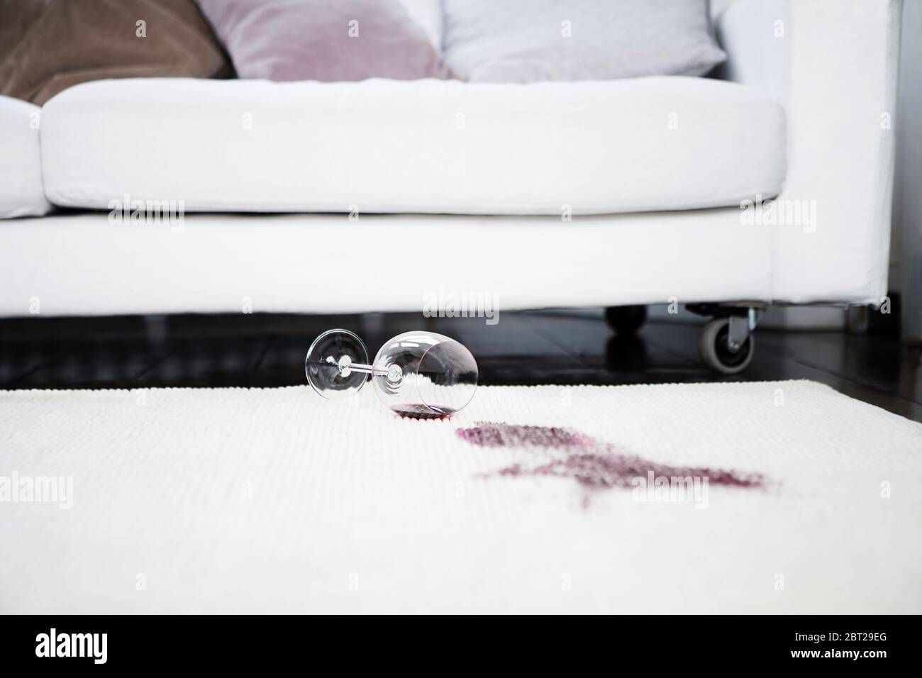 Vino rosso versato sul tappeto Foto Stock