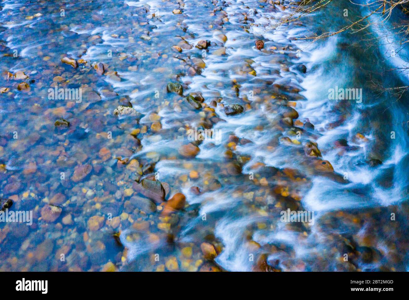 Letto di fiume con pietre rotolanti. Foto Stock