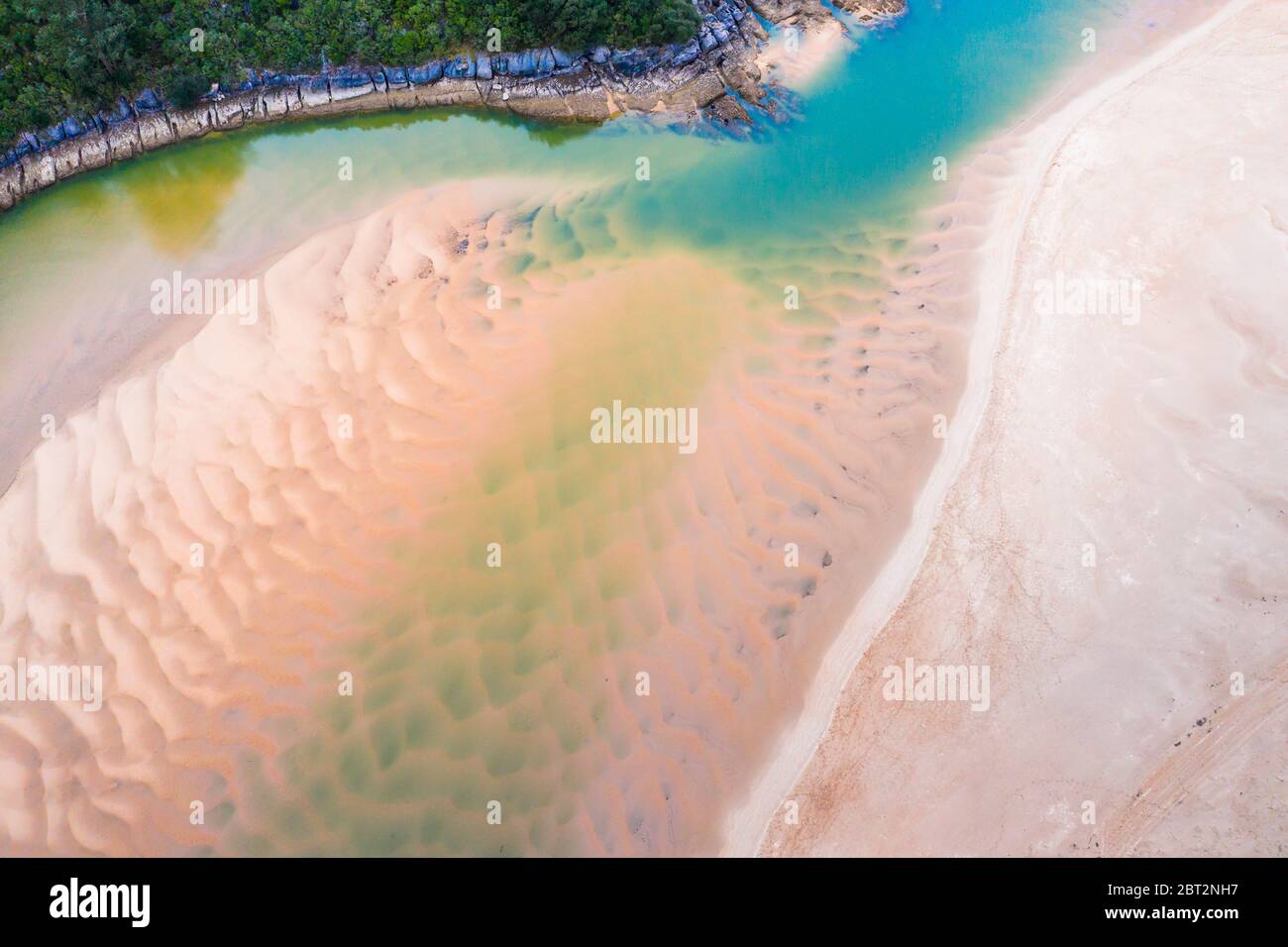 Sedimenti sabbiosi in bassa marea in un fiume vicino al mare. Foto Stock