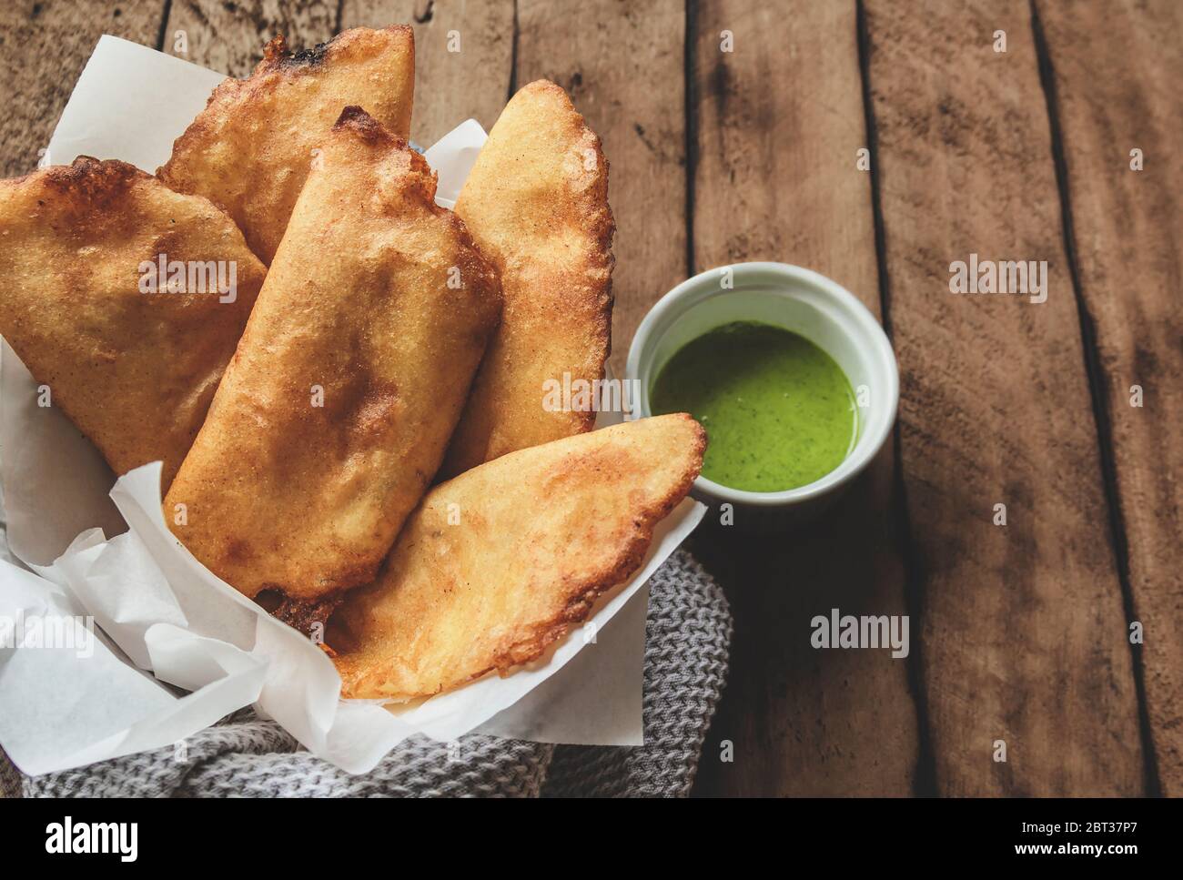 VENEZUELANO CUCINA COLOMBIANA. Empanadas di mais tipico venezuelano con carne in ciotola di argilla con salsa di avocado, empanadas fritti, farcito con pollo e mea Foto Stock