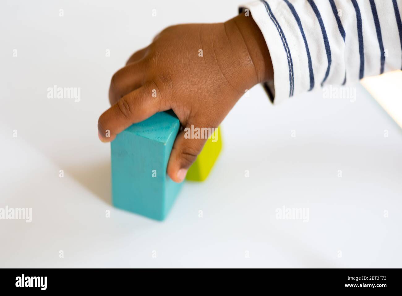 Bambino di un anno che gioca con colorati blocchi di legno da costruzione sul tavolo Foto Stock Bambino di un anno che gioca con colorati blocchi di legno da costruzione sul tavolo Foto Stock