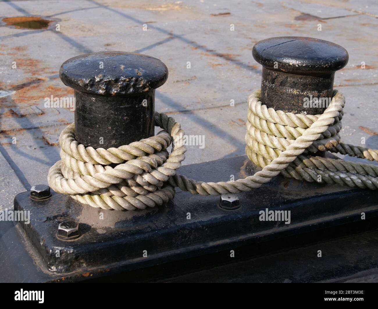 I pilastri neri sulla parete del porto per il fissaggio alla nave. Foto Stock