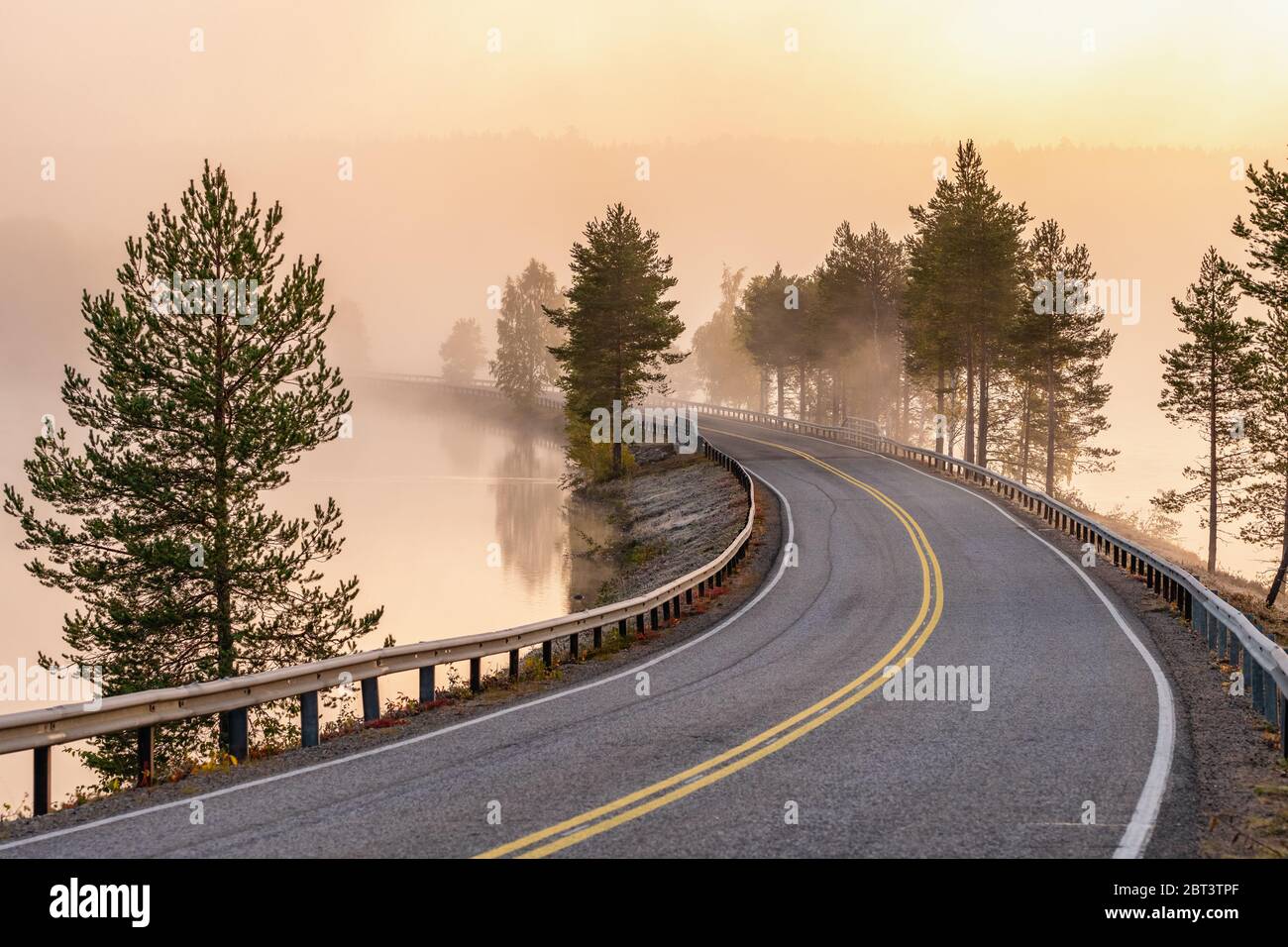 Paesaggio finlandese con strada stretta attraverso il lago. Foto Stock