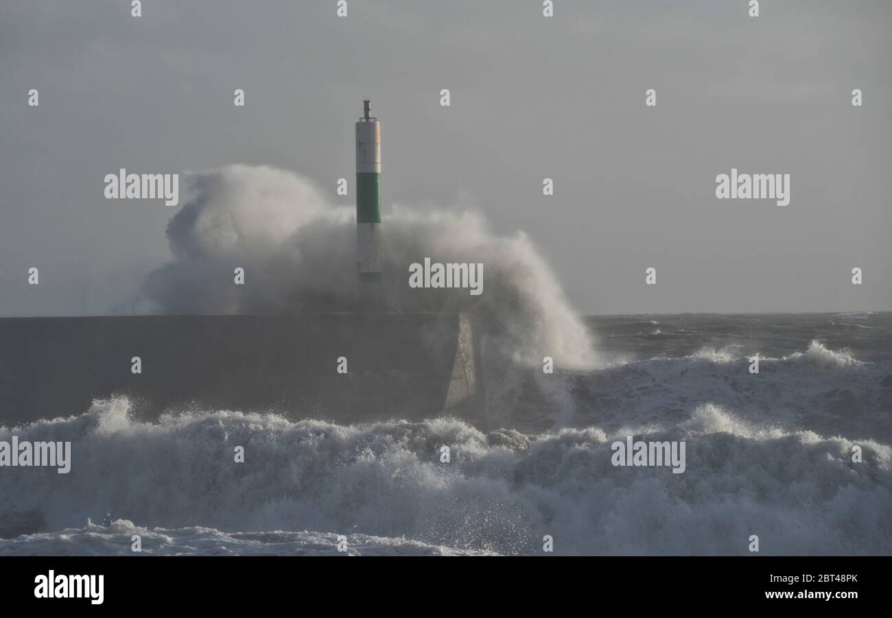 Le tempeste e grandi onde del mare le percosse il porto e il faro a Aberystwyth,Ceredigion,Galles,UK Foto Stock