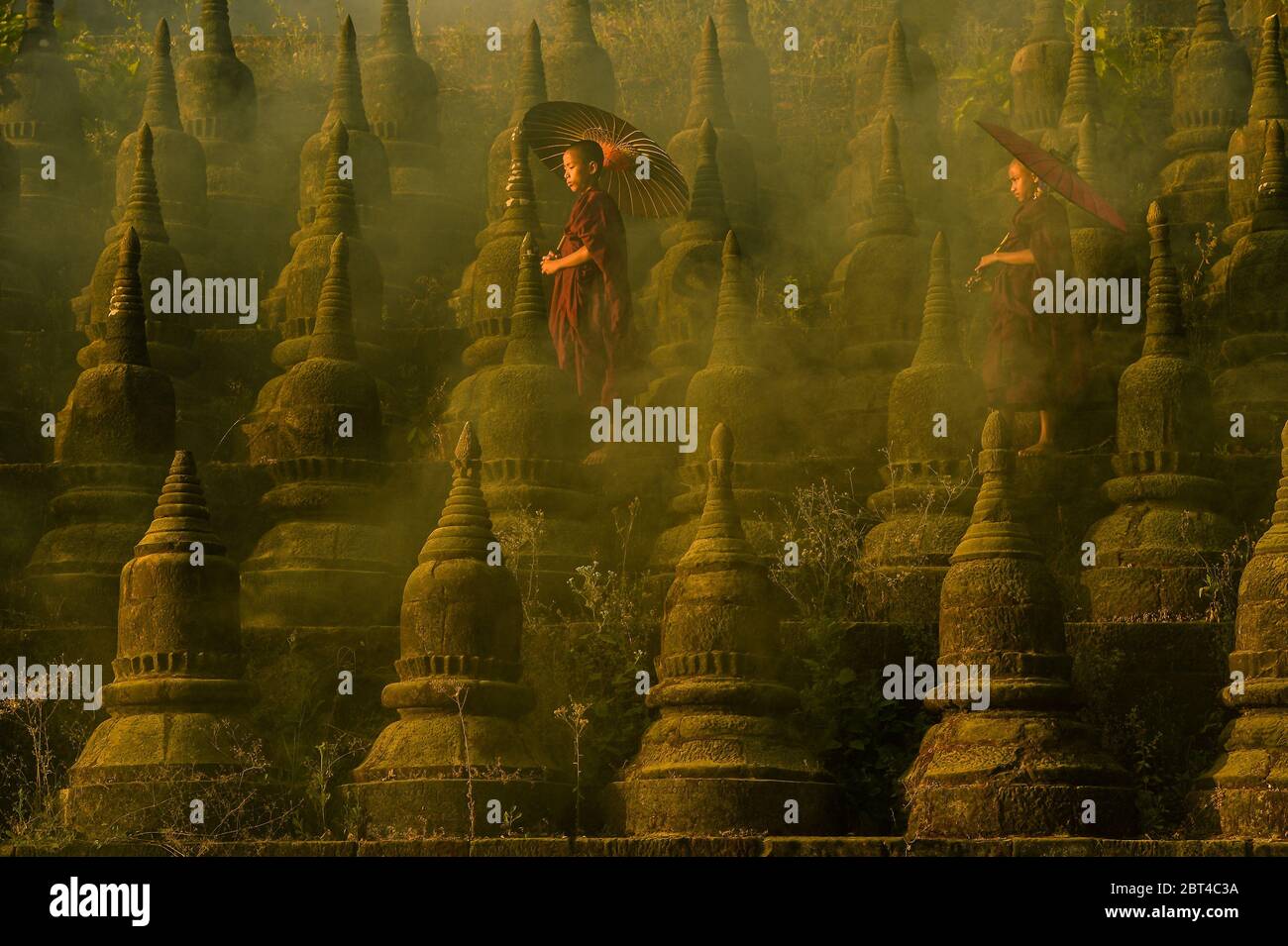 Due monaci novizi che camminano tra gli stupidi, Bagan, Mandalay, Myanmar Foto Stock