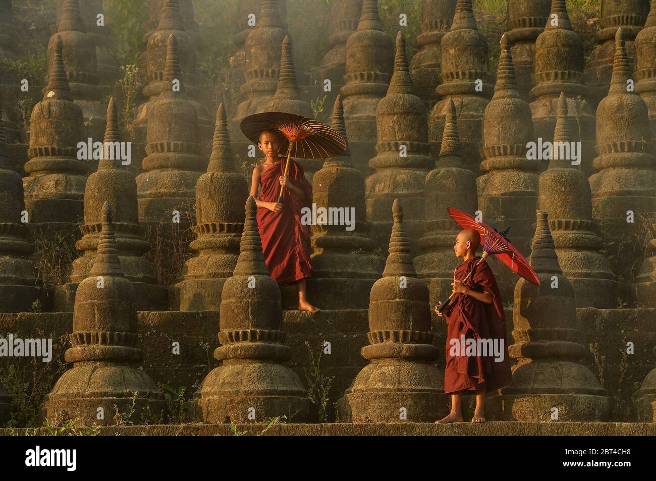 Due monaci novizi che camminano tra gli stupidi, Bagan, Mandalay, Myanmar Foto Stock