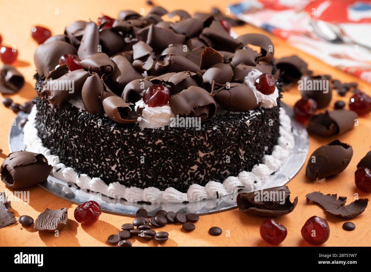 Torta della foresta nera con guarnizioni di cioccolato grattugiato,  ciliegia glassata su panna montata Foto stock - Alamy