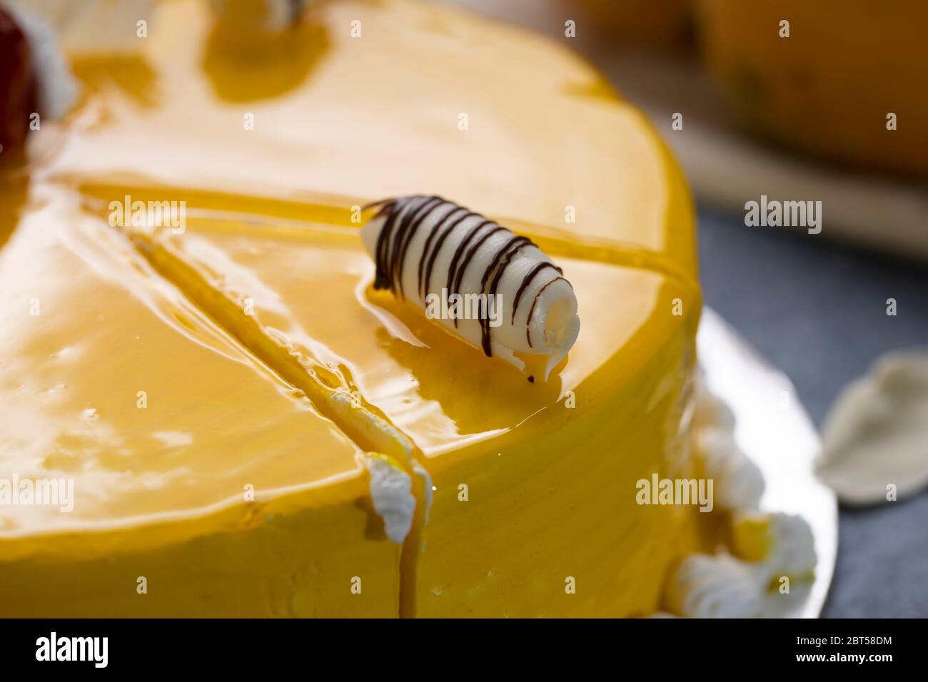 Cheesecake fresco con frutta di mango e smalto, il flan case fatto di biscotti briciole. Guarnizioni di fragola smaltate Foto Stock