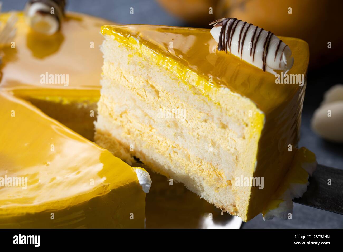Cheesecake fresco con frutta di mango e smalto, il flan case fatto di biscotti briciole. Guarnizioni di fragola smaltate Foto Stock