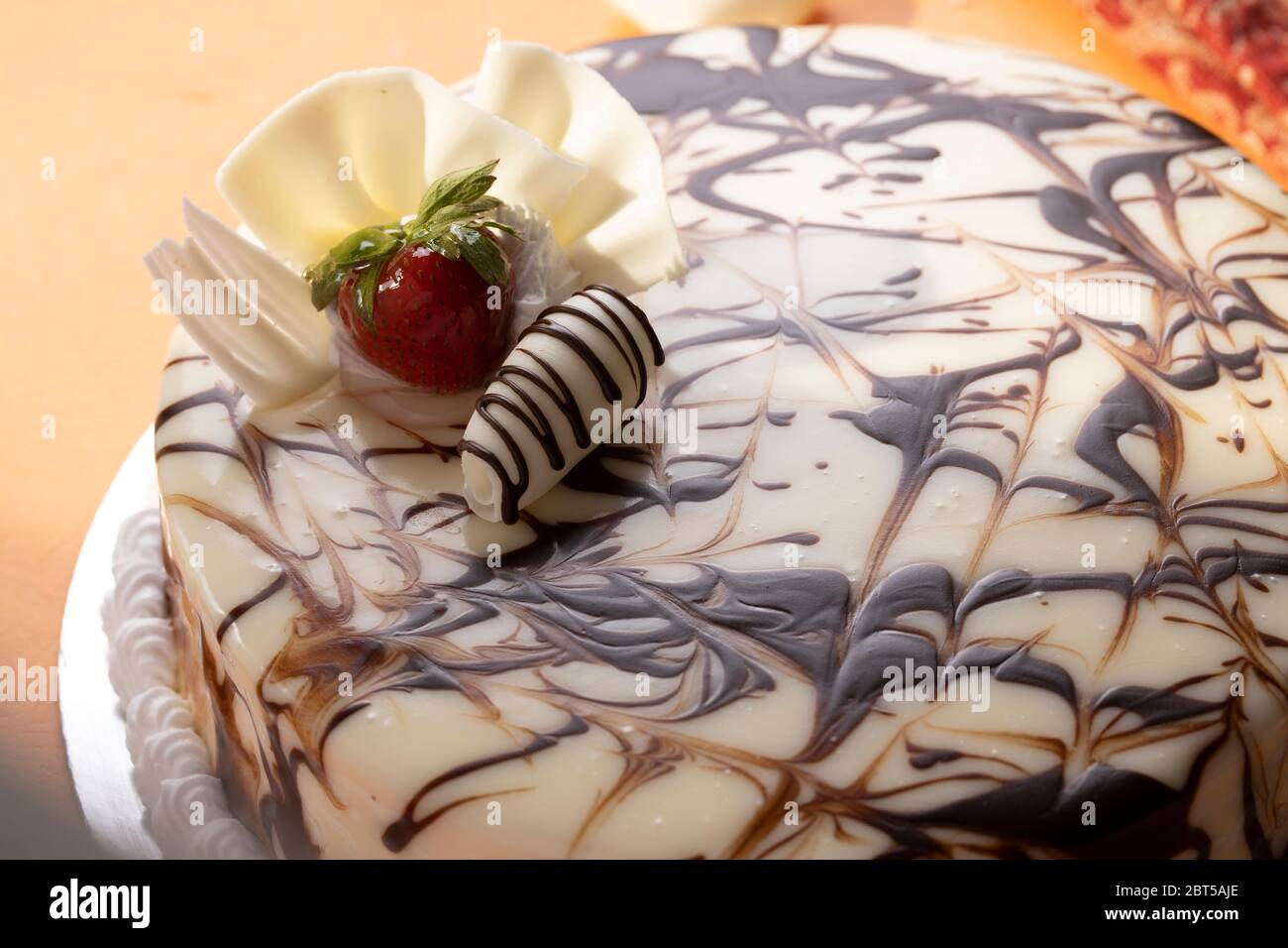 Torta mista alla vaniglia e al cioccolato con condimento glassato di fragole, fetta di torta, torta da 1 kg, torta bianca stratificata Foto Stock