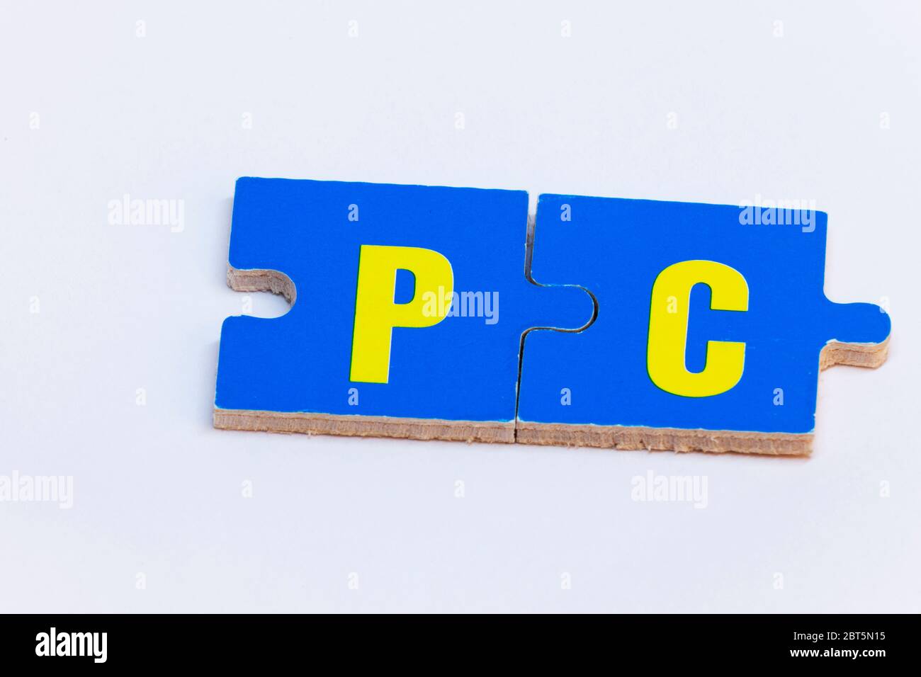 Pezzi di puzzle in blu e giallo che formano la parola PC su sfondo bianco Foto Stock