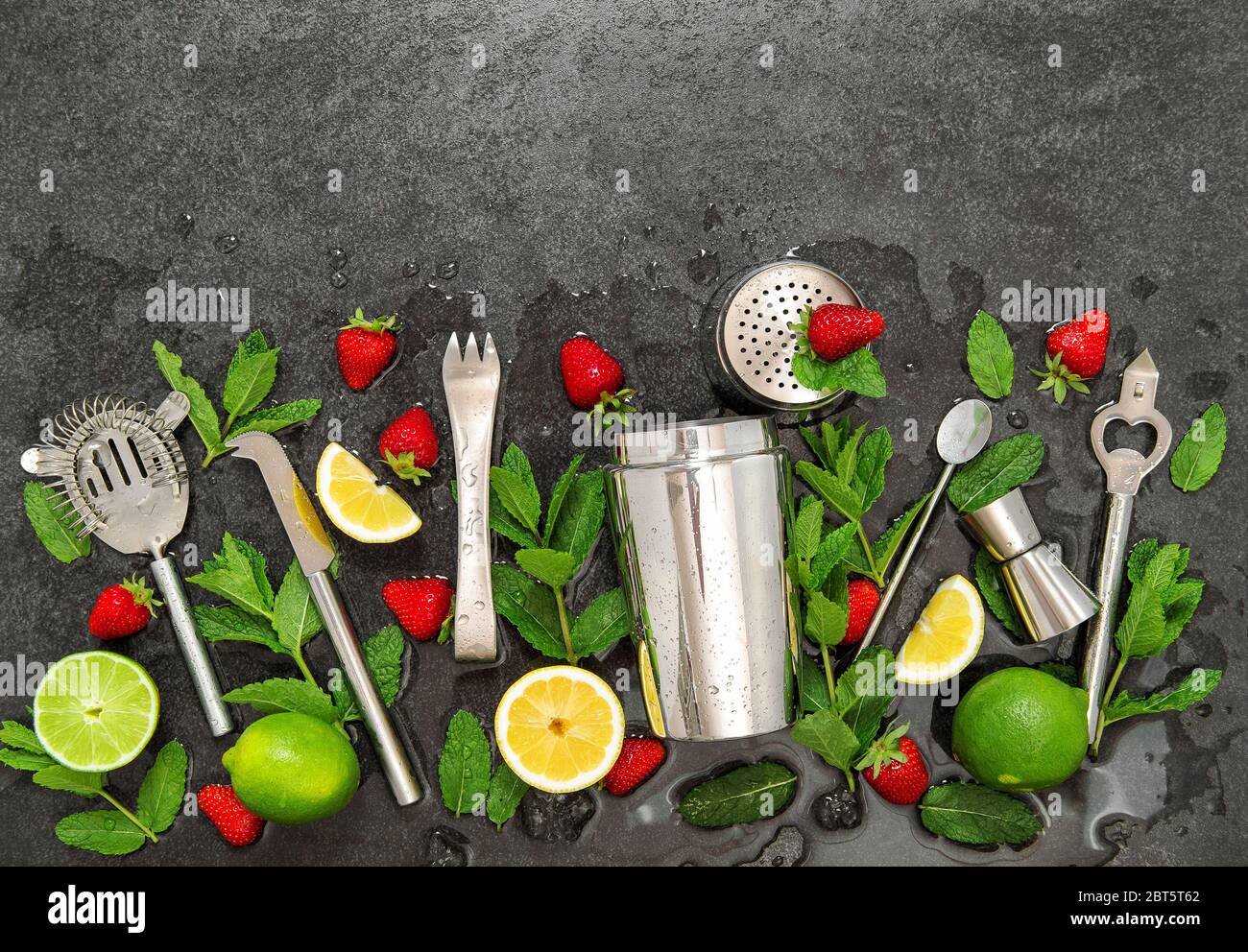 Accessori per barre. Ingredienti caipirinha cocktail drink. Fragola, lime, menta, limone, ghiaccio Foto Stock