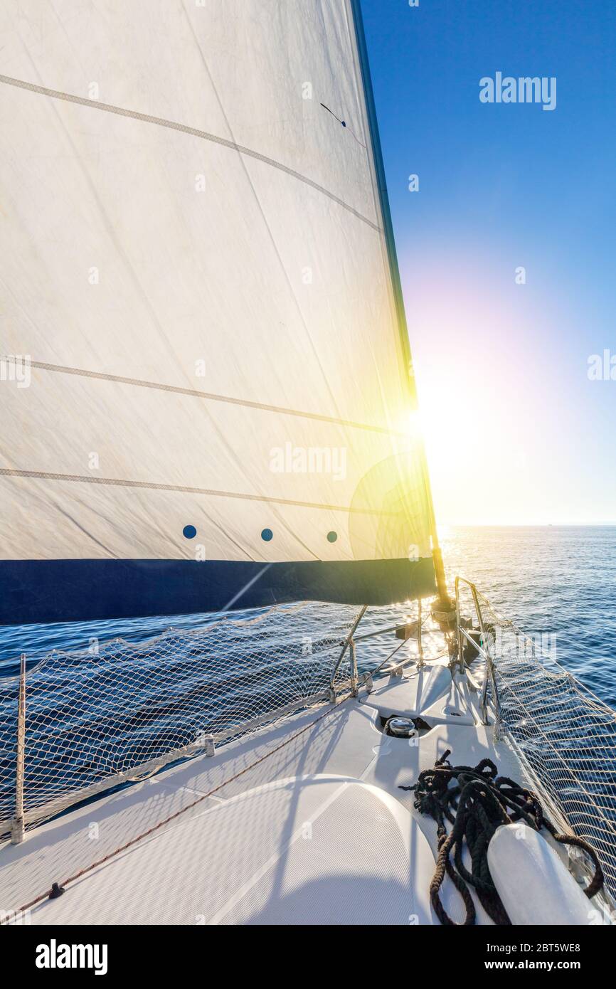 Vela con sole. Una vista dal ponte dello yacht alla prua e vele. Vela con vela a vela in mare aperto. Grecia, Europa Foto Stock