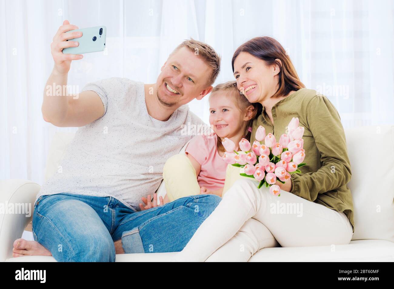 Felice famiglia che prende selfie con regali di festa Foto Stock