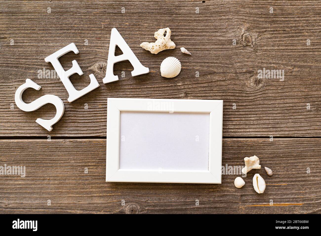iscrizione, cornice e conchiglie sul tavolo Foto Stock