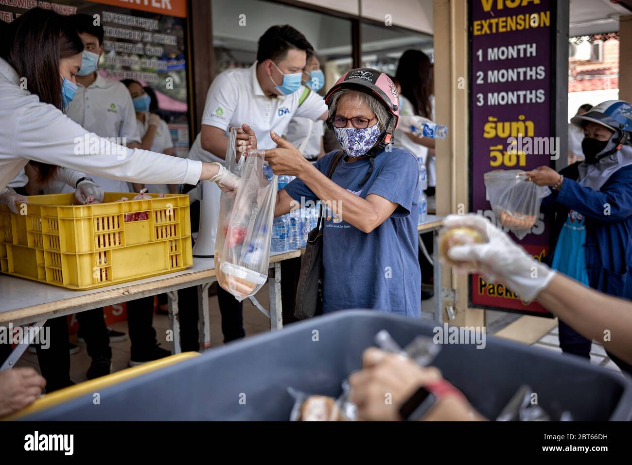 Covid-19 cibo. Consegna gratuita di cibo alle persone in necessità a causa della perdita di reddito da Coronavirus. La gente che dà fuori il cibo con le maschere. Thailandia Asia Foto Stock