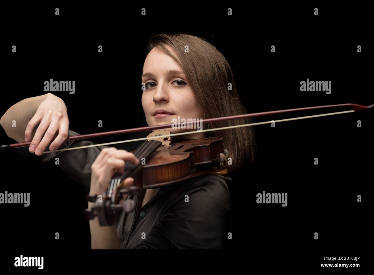 Violinista professionista appassionato su un antico violino barocco in legno artigianale che suona durante un concerto o una performance dal vivo con attenzione al tema Foto Stock