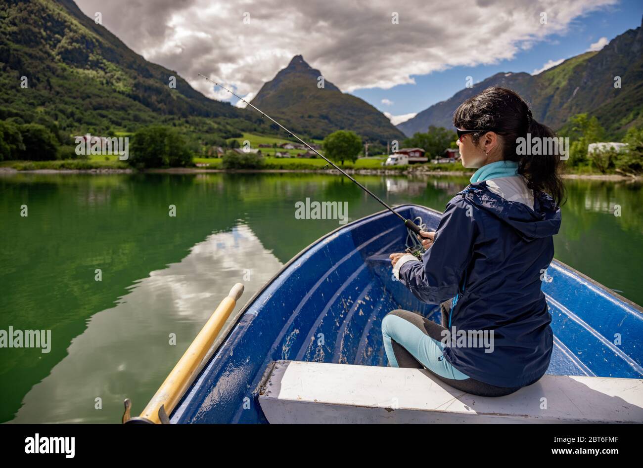 La donna la pesca su una barca. La bellissima natura della Norvegia paesaggio naturale. lovatnet lago Lodal valley. Foto Stock