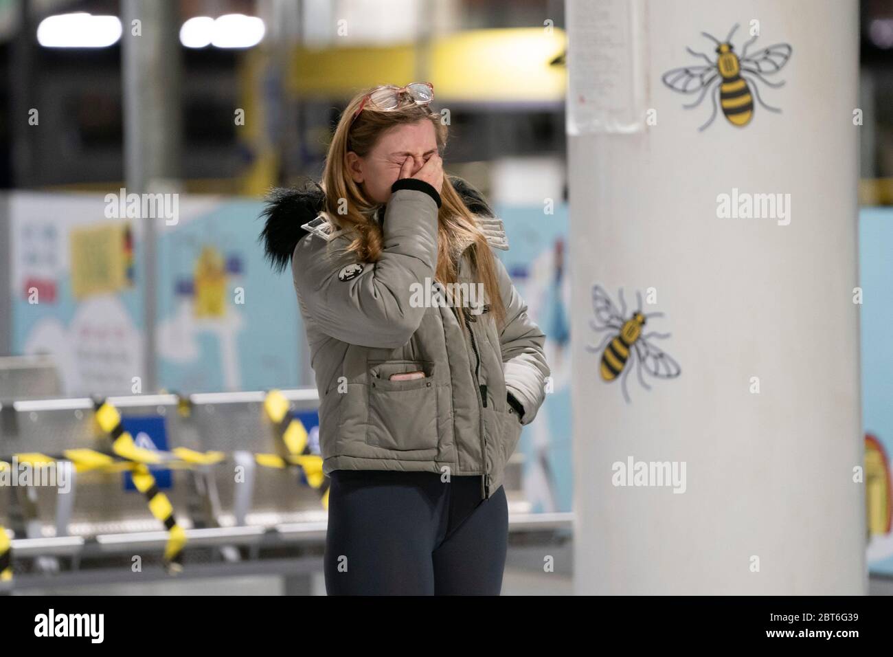 Manchester, Regno Unito. 22 maggio 2020. Un membro del pubblico grida come lei si trova in un memoriale alle vittime della Manchester Arena Bomb a Manchester Victoria stazione ferroviaria come il 3 ° anniversario dell'attacco terroristico è segnato con un minuteÕs silenzio, Manchester, Regno Unito. Credit: Jon Super/Alamy Live News. Foto Stock