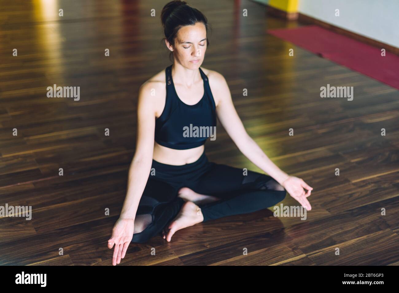 Giovane donna che fa yoga in posizione di meditazione Sukhasana. Concetto di relax Foto Stock