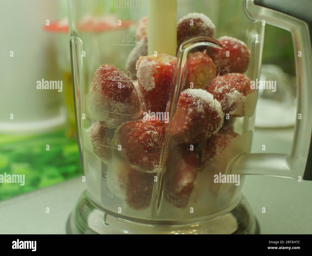 fragole surgelate fresche e succose in un primo piano del frullatore Foto Stock