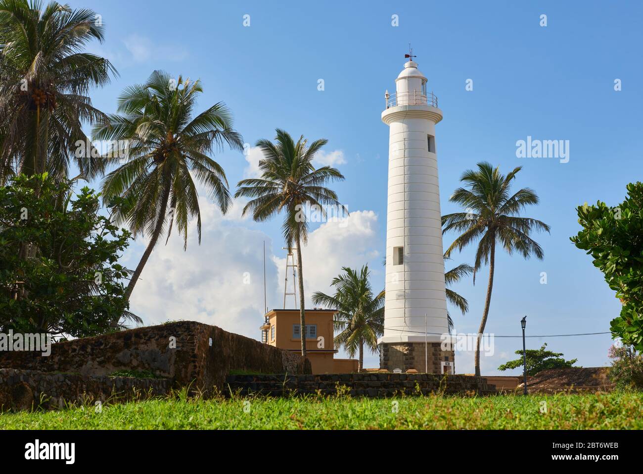 Foto diurna del famoso faro di Galle circondato da palme da cocco, a Fort Galle, Sri Lanka. Foto Stock