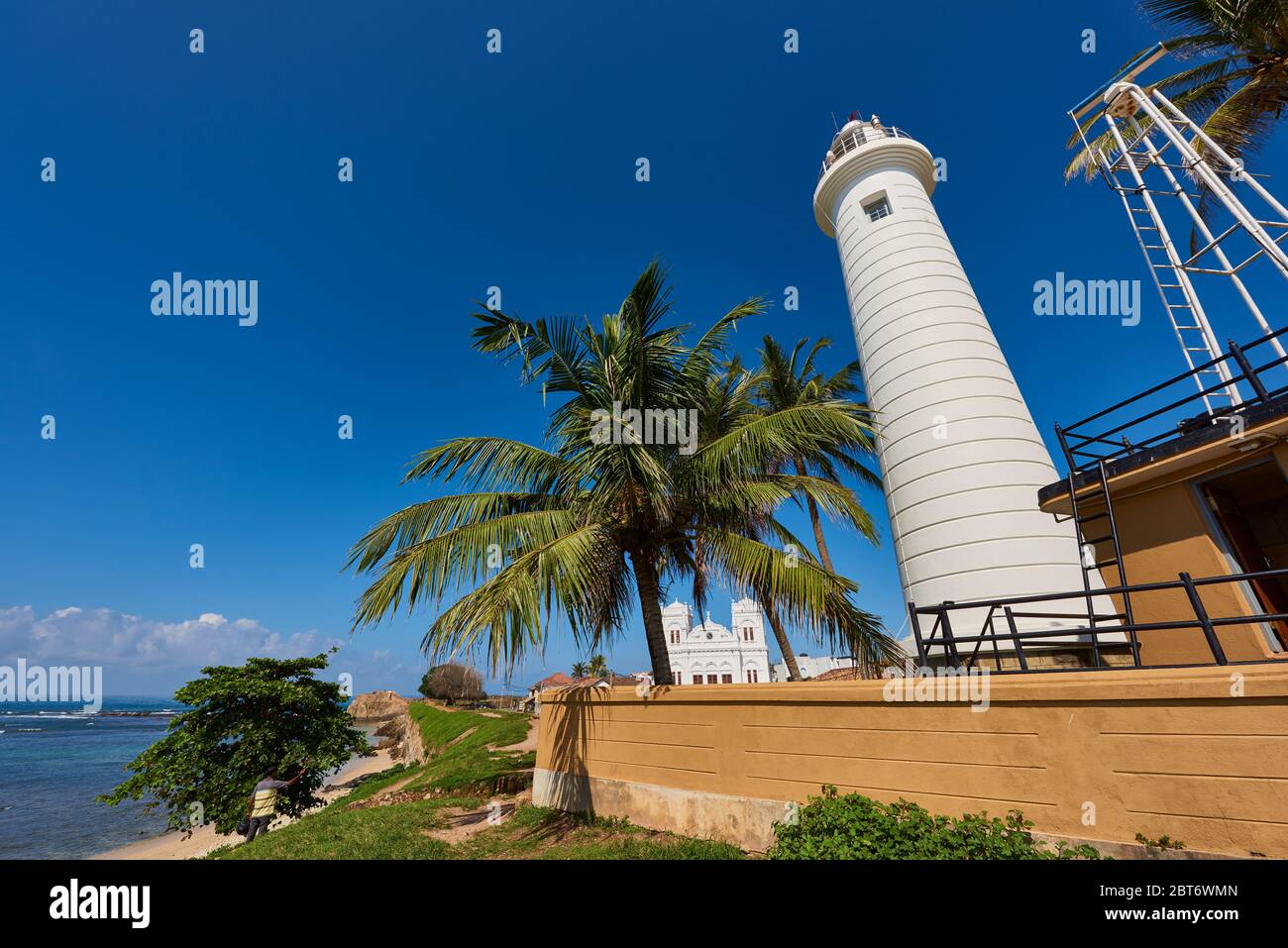 Foto diurna ad angolo basso del famoso Faro di Galle circondato da palme da cocco, a Fort Galle, Sri Lanka. Foto Stock