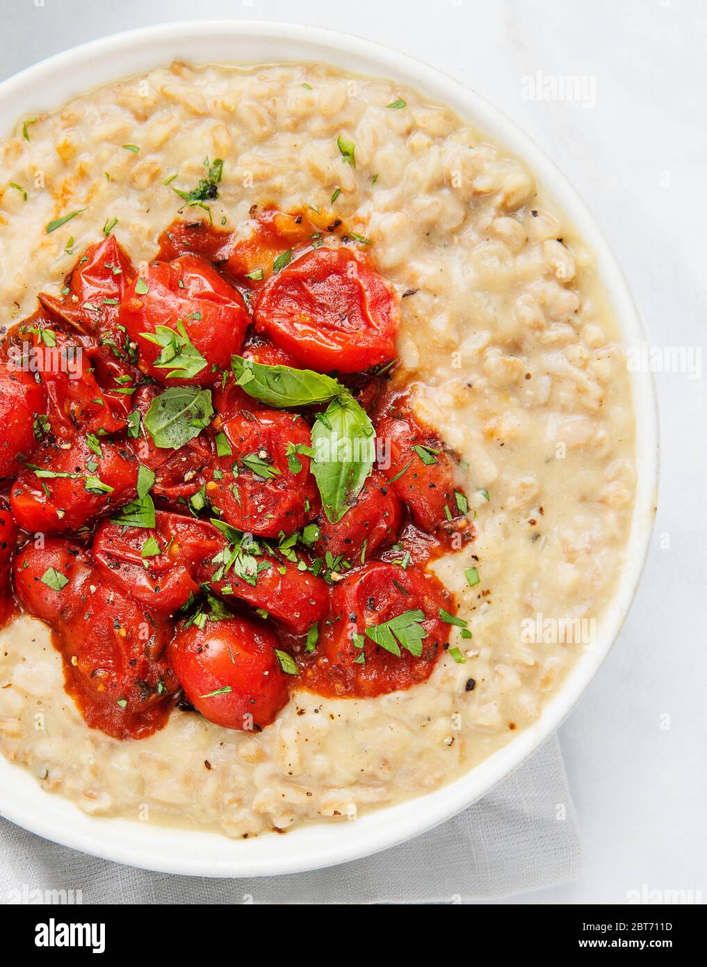 risotto cremoso con pomodori arrostiti e basilico Foto Stock