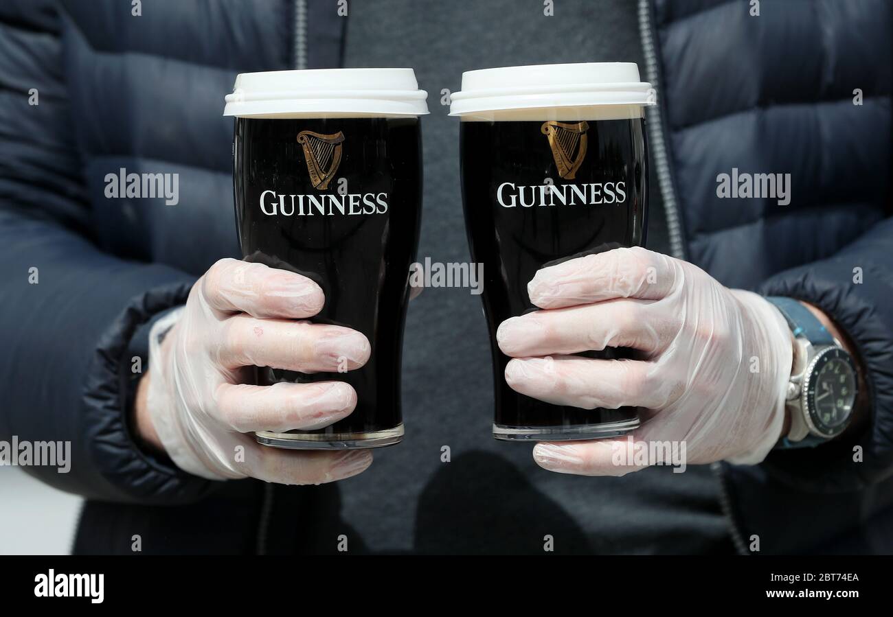 Albert Martin, che possiede e gestisce il pub Willows a Glasnevin, si prepara a consegnare due pinte di Guinness, mentre il pub ha avviato un servizio di consegna entro un chilometro dalla sede. Foto Stock