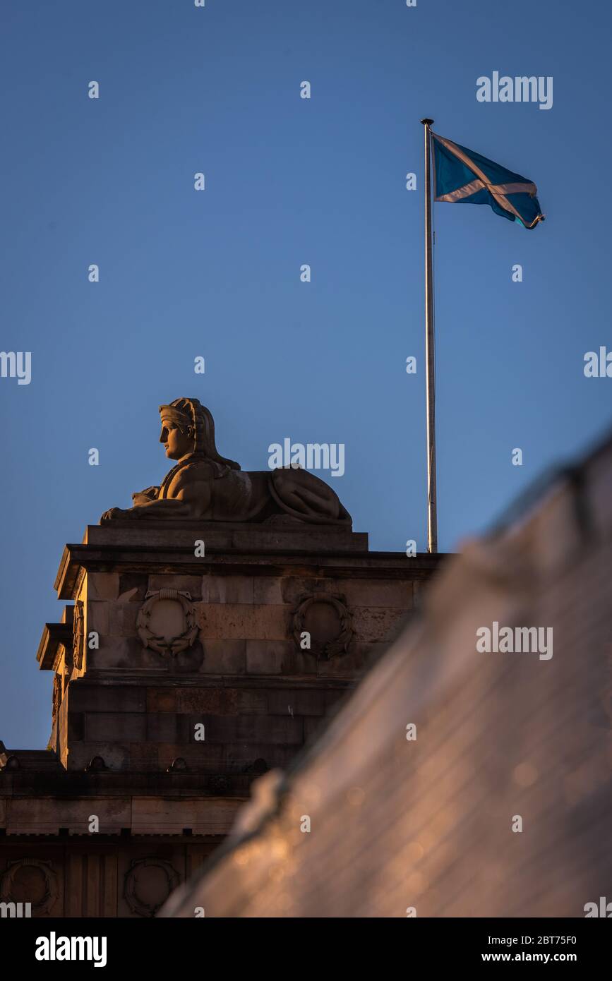 Statua di Sphynx sul tetto della National Gallery of Scotland con bandiera di salvataggio che vola contro il cielo blu Foto Stock