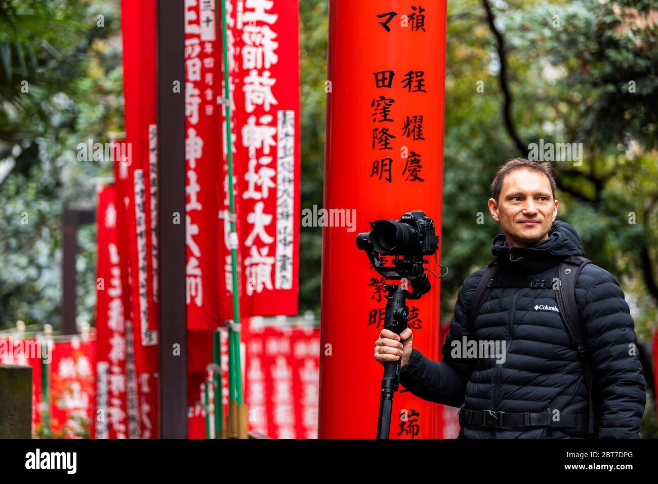 Tokyo, Giappone - 31 marzo 2019: Il santuario di HIE torii porta con l'uomo fotografo che filma gimbal e fotocamera nel quartiere di Akasaka reparto Foto Stock