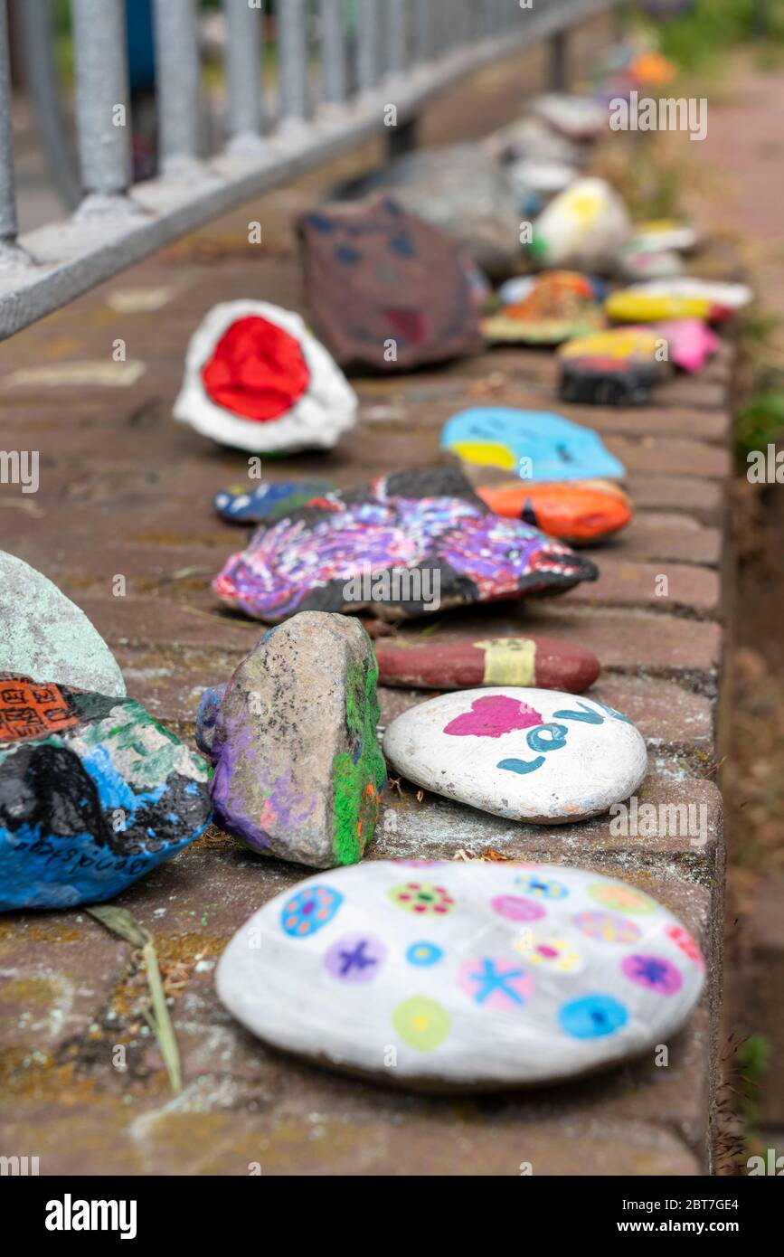 Pietre dipinte su un muro a Duisburg-Orsoy, le cosiddette pietre di Corona, serpenti di pietra, che per la maggior parte i bambini dipingono e si uniscono a una fila, azione di nuovo Foto Stock